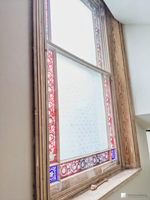 A stripped wood sash window fitted with colour matched WindowSkins secondary glazing using Subframe placement. A venting arms sits on the sill.