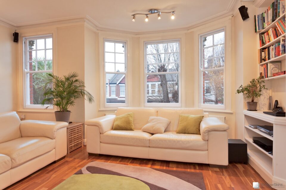 A modern lounge with four sash windows fitted with WindowSkins magnetic secondary glazing in the background