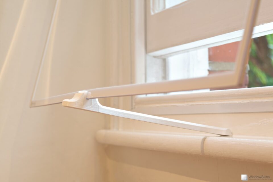 Closeup of a sash window WindowSkin propped open with venting arm