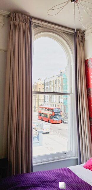 Noise reducing magnetic secondary glazing fitted to an arched sash hotel room window in Notting Hill