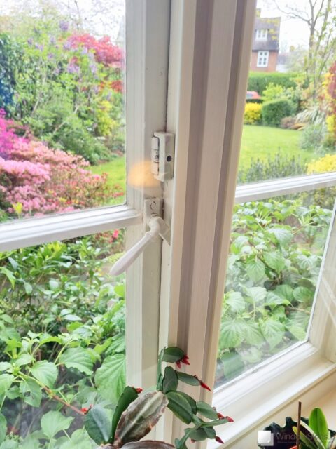 Closeup of colour matched WindowSkins magnetic secondary glazing set against a beige coloured timber casement window