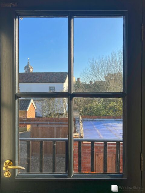 Black door fitted with a colour matched WindowSkins secondary double glazing panel