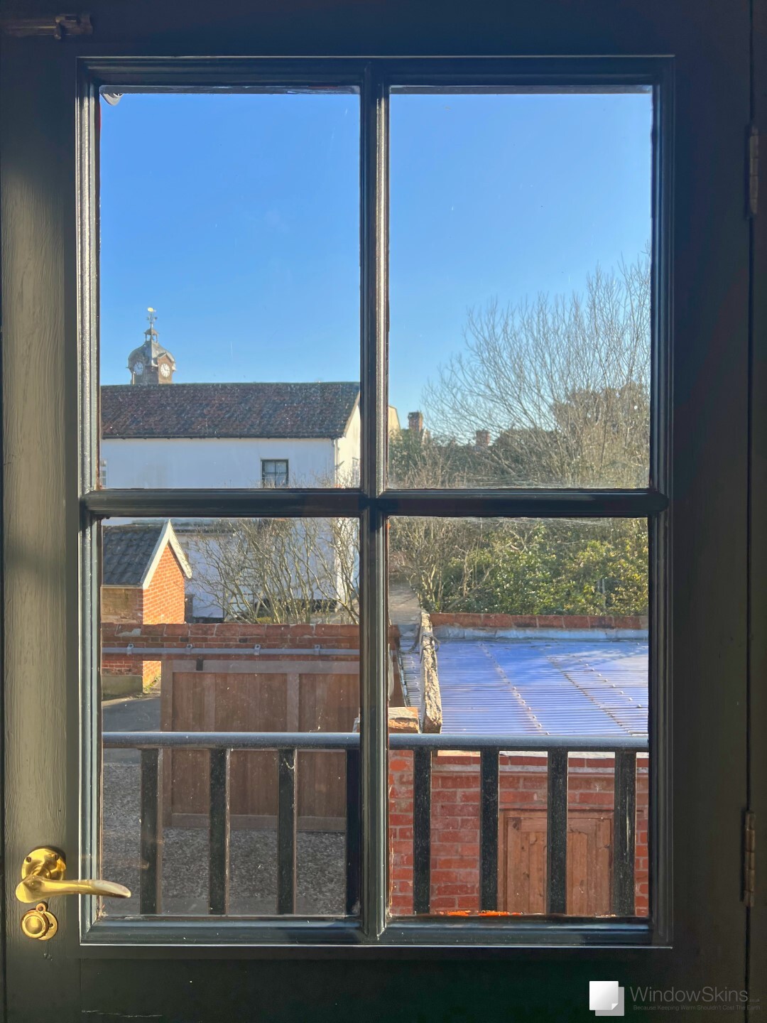 Black door fitted with a colour matched WindowSkins secondary double glazing panel