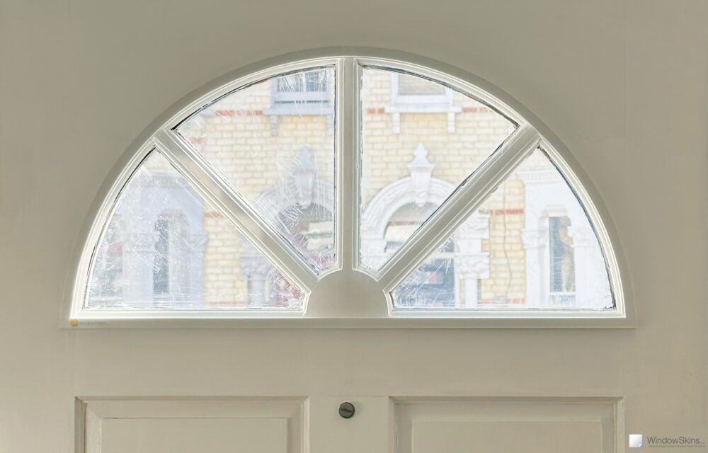 Half-moon front door window retrofit with a half-moon Perspex secondary glazing panel
