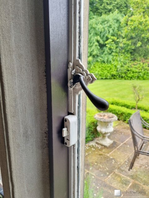 Left side closeup of a painted timber frame fitted to a stone mullion window in a listed property