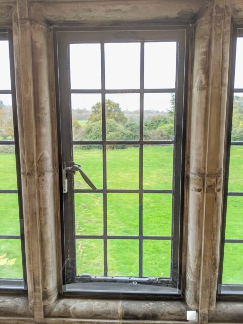 Leaded steel window set within stone mullion and fitted with colour matched WindowSkins magnetic secondary glazing