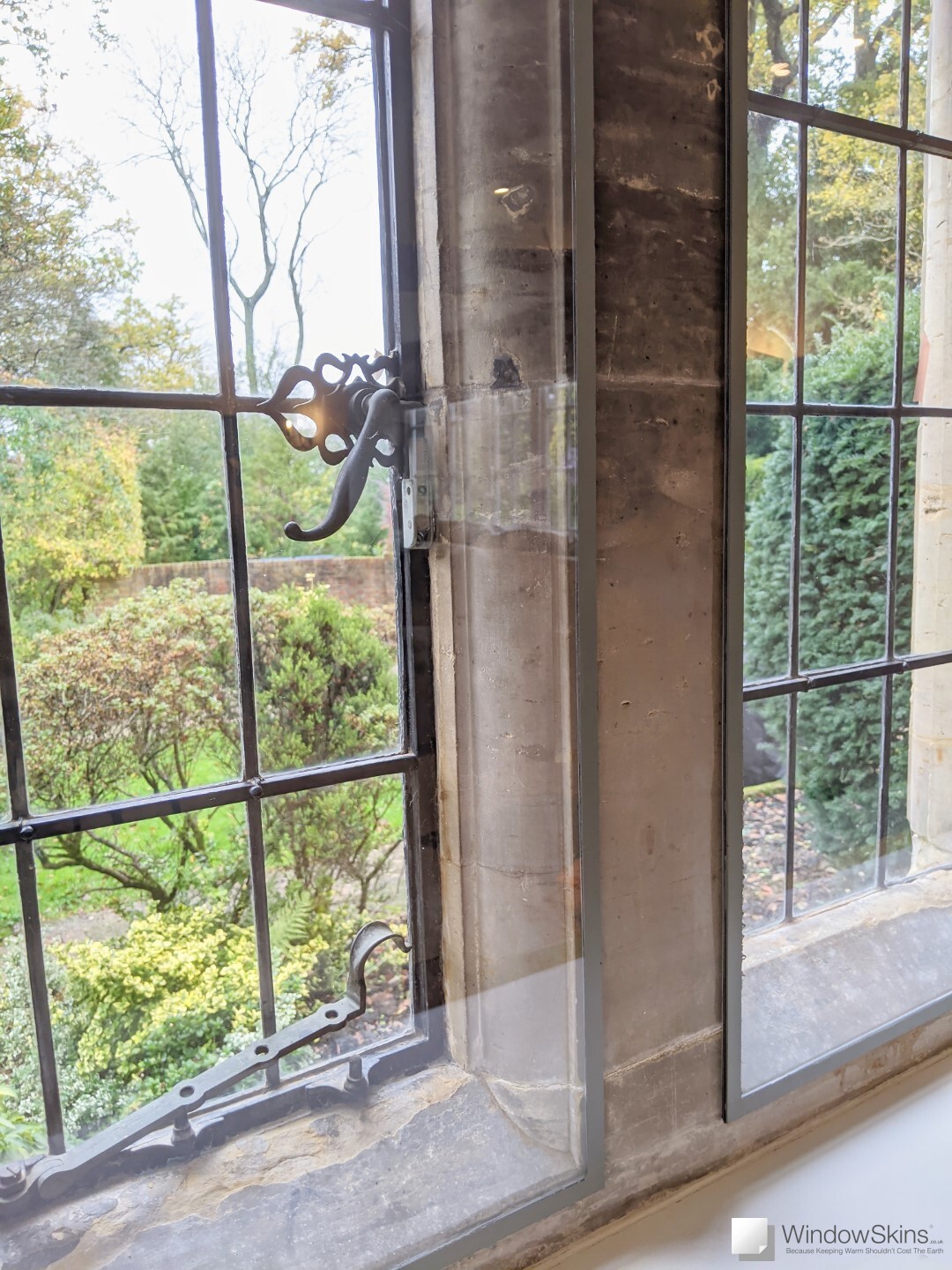 Closeup of colour matched WindowSkins magnetic secondary glazing retrofit to listed property stone mullion windows with metal windows and leaded lights