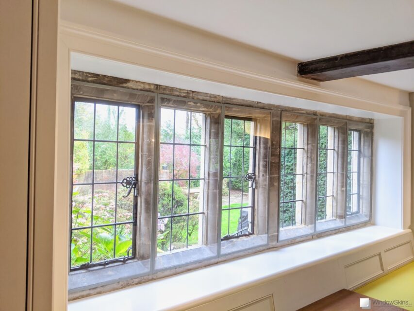Colour matched WindowSkins secondary glazing mounted on stone mullion windows with metal windows and leaded lights