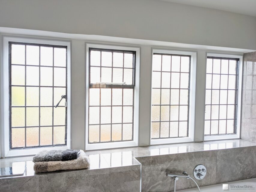 Bathroom with four white stone mullion windows, with secondary glazing installed
