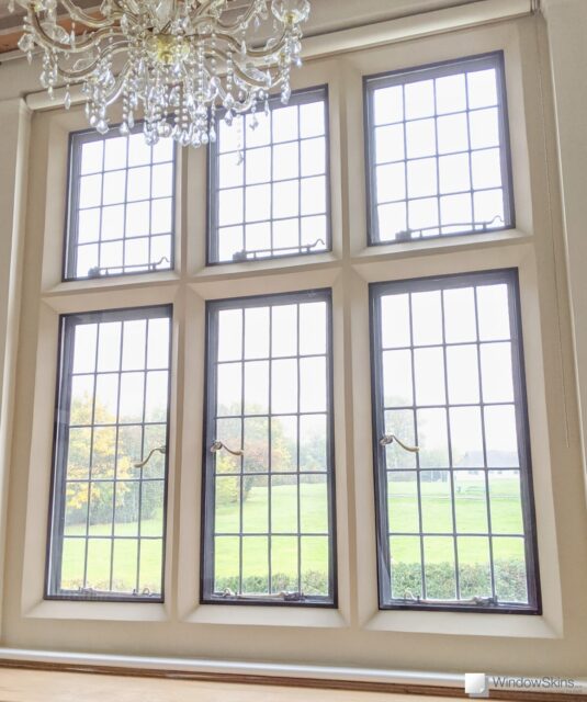 Six metal windows with leaded lights set in stone mullion and fitted with WindowSkins magnetic secondary glazing