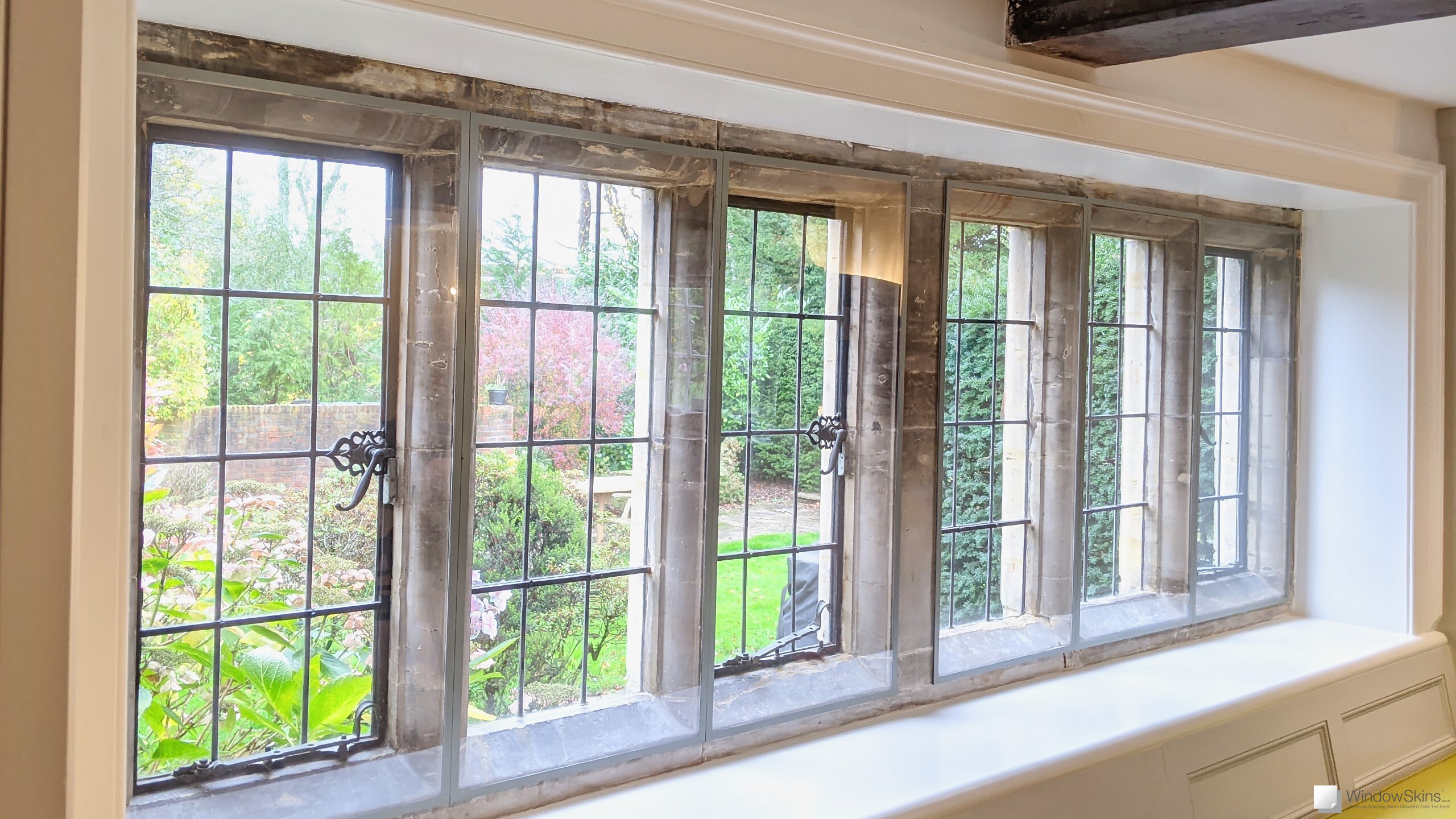 Colour matched WindowSkins secondary glazing mounted on stone mullion windows with metal windows and leaded lights
