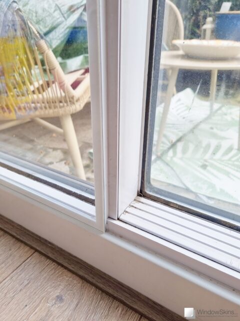 Close-up of magnetic triple glazing retrofit to a uPVC sliding patio door to reduce draughts and improve thermal insulation. The patio door remains fully functional