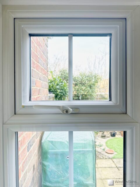 Magnetic triple glazing panel fitted to small double glazed uPVC window to reduce condensation and heat loss