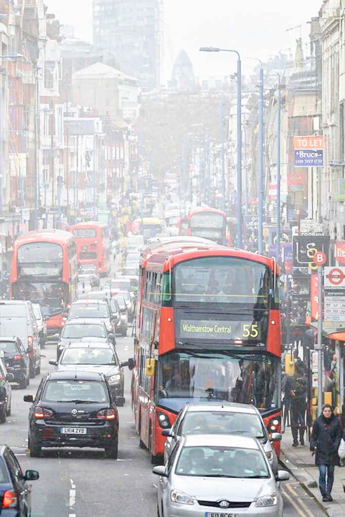 A busy London street scene, full of pollution, noise, heavy traffic and pedestrians